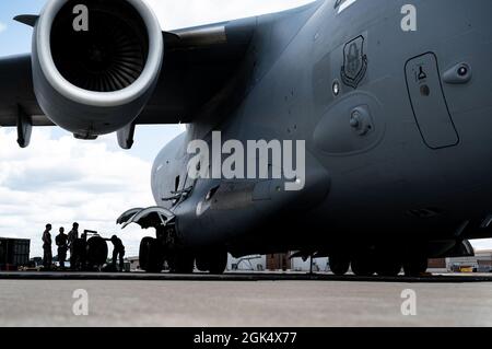 Gli airmen assegnati al 911th Maintenance Group cambiano un pneumatico di atterraggio su un C-17 Globemaster III alla stazione di riserva aerea dell'aeroporto internazionale di Pittsburgh, Pennsylvania, 2 agosto 2021. Gli pneumatici degli aeromobili devono essere sostituiti se si rileva che superano i limiti di usura per garantire la sicurezza dell'equipaggio all'atterraggio e al decollo. Foto Stock