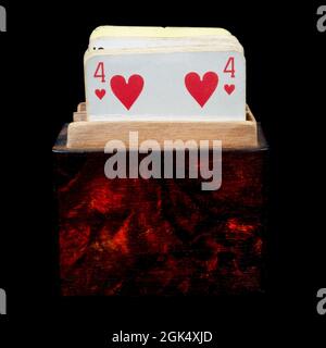 Vintage mazzo di carte da gioco in una scatola di legno isolato su uno sfondo nero Foto Stock
