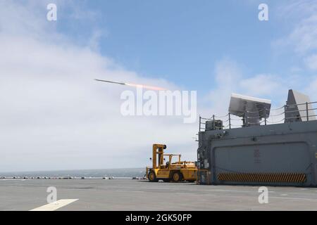 210803-N-CZ759-1004 OCEANO PACIFICO (AGOSTO 3, 2021) – Un missile mobile RIM-116 (RAM) viene lanciato dal lanciatore in avanti durante un esercizio di fuoco a bordo di una nave d'assalto anfibio USS Tripoli (LHA 7), 3 agosto. Tripoli sta conducendo operazioni di routine nella terza flotta statunitense. Foto Stock