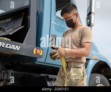 Airman 1st Class Manich Prak, 2nd Logistics Readiness Squadron Ground Transportations Specialist, arrotola una cinghia alla base dell'aeronautica di Barksdale, Louisiana, 2 agosto 2021. I professionisti del trasporto a terra dell'aeronautica mantengono i veicoli di base e forniscono le opzioni di trasporto per le varie agenzie di base. Foto Stock