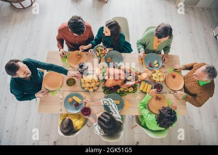 Top sopra alto angolo di vista ritratto di adorabile cheery attento famiglia mangiare piatto fatto in casa carne autunno caduta a casa al chiuso Foto Stock