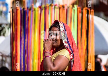 Orchha, Madhya Pradesh, India - Marzo 2019: Un ritratto candido di una donna indiana vestita in un sari colorato in un mercato. Foto Stock