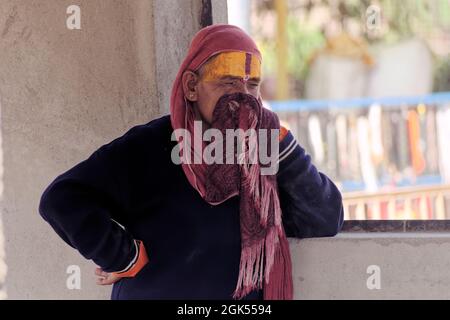 Orchha, Madhya Pradesh, India - Marzo 2019: Un ritratto candido di una donna indù indiana pellegrina vestita in nero fissando pensosamente. Foto Stock