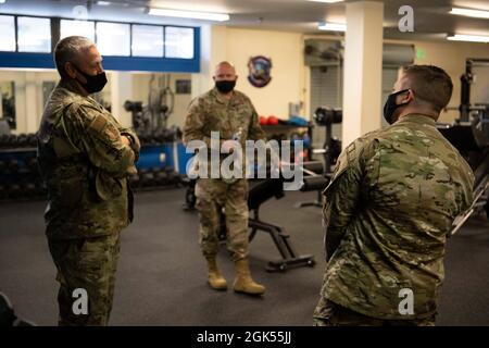Personale degli Stati Uniti Sgt. Ryan Robinson, a destra, 660° Aircraft Maintenance Squadron comunicazione e navigazione artigiano e squadrone fisico di formazione leader, mostra col. Corey Simmons, a sinistra, 60o Air Mobility Wing comandante e Capo Master Sgt. Robert Schultz, centro, 60esimo capo comando AMW, la 660esima palestra AMXS durante i giri di leadership del 4 agosto 2021, presso la base dell'aeronautica di Travis, California. Il tour delle strutture si svolge alla luce dei recenti cambiamenti apportati alla valutazione del fitness fisico dell'aeronautica. Il programma Leadership Rounds offre alla 60a leadership AMW l'opportunità di interagire con Airmen e ricevere un deta Foto Stock