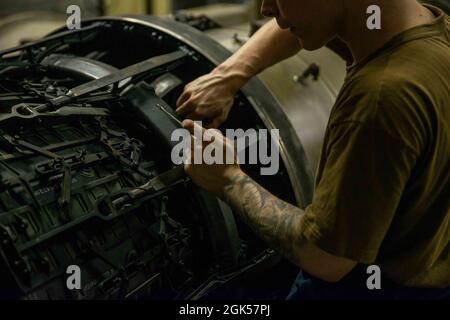 210805-N-DW158-1018 MAR ARABICO (AGOSTO 5, 2021) – Aviation Machinist’s Mate 2nd Class Nicholas Carroll esegue la manutenzione sul postbruciatore di un motore a reazione F/A-18 Super Hornet nel jet shop a bordo della portaerei USS Ronald Reagan (CVN 76) nel Mare Arabico, 5 agosto. Ronald Reagan è schierato nella 5th Fleet area degli Stati Uniti di operazioni a sostegno delle operazioni navali per garantire la stabilità e la sicurezza marittima nella regione centrale, collegando il Mediterraneo e il Pacifico attraverso l'Oceano Indiano occidentale e tre punti di arresto strategici. Foto Stock