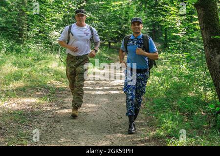 SGT. 1° Classe Shane Price (a sinistra), 108° comando di addestramento, corre accanto ad un soldato rumeno della Riserva della Difesa aerea durante un evento di addestramento di orienteering a Sibiu, Romania, 5 agosto. I soldati di riserva e gli Airmen sono stati invitati a condurre un evento di formazione bilaterale per preparare i soldati di riserva della Romania alla futura competizione militare della Confederazione interalleata dei funzionari di riserva. Nel corso della settimana si alleneranno sul mercato, le abilità di base di orientamento e altre attività fisiche. Foto Stock