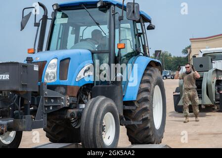 Gli airmen del 2nd Logistics Readiness Squadron rimuovono un trattore da un camion a pianale alla base dell'aeronautica di Barksdale, Louisiana, 9 agosto 2021. I professionisti del trasporto a terra dell'aeronautica mantengono i veicoli di base e forniscono le opzioni di trasporto per le varie agenzie di base. Foto Stock