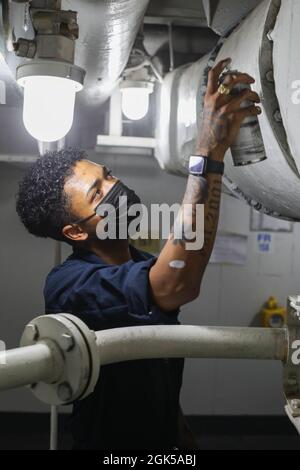 OCEANO PACIFICO (agosto 5, 2021) Aviation Ordnanceman Airman Cameron Cordova, da Los Angeles, conduce la manutenzione su tubi a bordo della portaerei USS Abraham Lincoln (CVN 72). Abraham Lincoln sta conducendo le operazioni di routine nell'area di operazioni della terza flotta degli Stati Uniti. Foto Stock