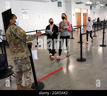 New York Army National Guard SPC Ackeem Whyte, 27th BCT indica i pazienti vaccinati alla loro stazione medica presso il sito Vaccine Point of Distribution situato presso la Stony Brook University, li, NY, il 5 agosto 2021. Il sito ha aiutato la somministrazione di oltre 262,000 vaccini da quando è stato istituito nel gennaio 2021. Le forze militari dello Stato di New York continuano a sostenere diversi siti di vaccinazione in tutto lo Stato come parte degli sforzi in corso per vaccinare il maggior numero possibile di newyorkesi. Foto Stock