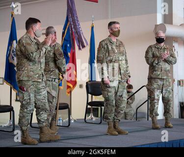 Briga. Il Gen. Jeffrey Wilkinson (a sinistra), assistente generale del Kentucky per Air, e il col. David Mounkes (a destra), comandante uscente della 123esima Ala Airlift della Guardia Nazionale aerea del Kentucky, applaudono il col. Bruce Bancroft, Che ha preso ufficialmente il comando dell'ala durante una cerimonia alla base della Guardia Nazionale aerea del Kentucky a Louisville, Ky., 7 agosto 2021. Mounkes, che era stato comandante di ala dal 2016, è stato nominato direttore della politica per le operazioni aeree, i piani e i programmi presso la sede centrale delle forze congiunte, Kentucky. Foto Stock