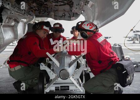 OCEANO PACIFICO (agosto 7, 2021) i Marines assegnati ai “Cavalieri neri” di Marine Fighter Attack Squadron (VMFA) 31 rimuovono l'ordnance da un F-35C Lightning II a bordo della portaerei USS Abraham Lincoln (CVN 72). Abraham Lincoln sta conducendo le operazioni di routine nell'area di operazioni della terza flotta degli Stati Uniti. Foto Stock