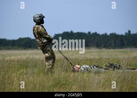 Un membro dell'equipaggio di UH-60 Blackhawk, 2-211th Aviation Regiment, Iowa National Guard, trascina un manichino mentre partecipa ad un addestramento di sollevamento di salvataggio durante il Northern Strike 21-2, 8 agosto 2021, all'aeroporto dell'esercito di Grayling, Grayling, Michigan. NS è uno dei più grandi esercizi congiunti del Dipartimento della Difesa, volti ad aumentare l’interoperabilità tra i servizi e i componenti della nostra nazione. Foto Stock