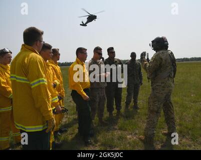 Un membro dell'equipaggio UH-60 Blackhawk, 2-211th Aviation Regiment, Iowa National Guard, briefing U.S Marines from the Combat Logistics Battaglione 451, Marine Corps Reserve, e vigili del fuoco dal 482nd Engineer Detachment, Army Reserve, sulle operazioni di salvataggio degli argani durante il Northern Strike 21-2, 8 agosto 2021, al Grayling Army Airfield, Grayling Army, Michigan. NS è uno dei più grandi esercizi congiunti del Dipartimento della Difesa, volti ad aumentare l’interoperabilità tra i servizi e i componenti della nostra nazione. Foto Stock