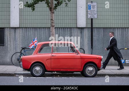 Hillman Imp, una piccola auto economica a due porte prodotta dal 1963 al 1976, parcheggiata lungo la strada a Kensington, nel centro di Londra, Inghilterra, uni Foto Stock