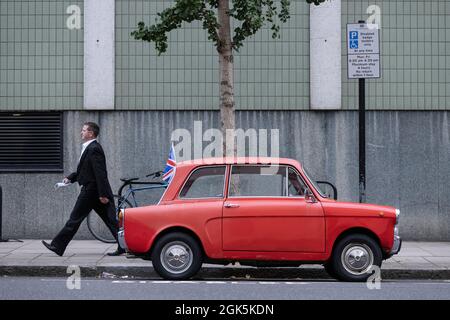 Hillman Imp, una piccola auto economica a due porte prodotta dal 1963 al 1976, parcheggiata lungo la strada a Kensington, nel centro di Londra, Inghilterra, uni Foto Stock