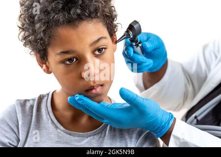 ENT medico che guarda nell'orecchio del paziente con uno strumento , Bambino che soffre di dolore all'orecchio Foto Stock