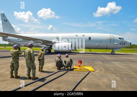 Marine Wing Support Squadron 271 Aviation Mobility Company FARP Platoon Marines con il supporto di Navy Cargo Handling Battaglione UN marinaio si prepara a respingere un P-8 Poseidon di Patrol e Reconnaissance Squadron (VP) 26 in un punto di armamento e rifornimento in avanti (FARP), dimostrando l'integrazione delle capacità di forza a Kinston, N.C. come parte di Large-Scale Exercise (LSE 2021), 10 agosto 2021. LSE 2021 dimostra la capacità della Marina di impiegare una forza precisa, letale e schiacciante a livello globale attraverso tre comandi di componenti navali, cinque flotte numerate e 17 fusi orari. LSE 2021 si unisce vivere un Foto Stock