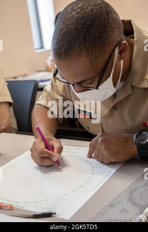 Uno studente di classe 16-21 dell'Officer Candidate School (OCS) presso l'Officer Training Command Newport (OTCN), Rhode Island, disegna il punto successivo della stazione su un bordo di manovra durante una classe di staiting e manovra della nave, agosto 10. OCS sviluppa i civili e i marinai della flotta in ufficiali appena commissionati moralmente, mentalmente e fisicamente e li impregia con i più alti ideali di onore, di coraggio e di impegno per il servizio nella flotta come ufficiali Navali. Foto Stock