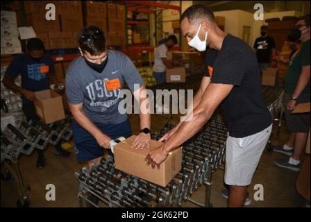 I membri dell'equipaggio che si trovano sulla US Coast Guard Cutter Harriet Lane preparano scatole di prodotti in scatola presso la Foodbank della Virginia sudorientale e la costa orientale a Norfolk, Virginia, 11 agosto 2021. L'equipaggio ha assemblato oltre 350 scatole di prodotti in scatola che saranno utilizzati per fornire pasti per le persone che sperimentano l'insicurezza alimentare in tutta la Virginia sudorientale e sulla riva orientale. Foto Stock