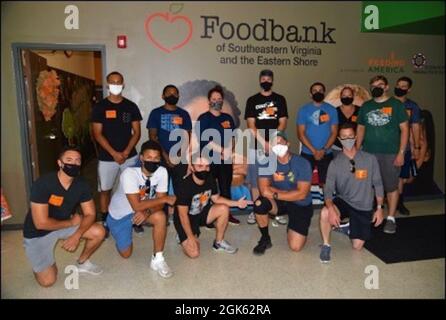 I membri della crewmembers che si trovano sulla US Coast Guard Cutter Harriet Lane posano per una foto mentre si offrono volontariamente alla Foodbank della Virginia sudorientale e alla costa orientale a Norfolk, Virginia, 11 agosto 2021. L'equipaggio ha assemblato oltre 350 scatole di prodotti in scatola che saranno utilizzati per fornire pasti per le persone che sperimentano l'insicurezza alimentare in tutta la Virginia sudorientale e sulla riva orientale. Foto Stock