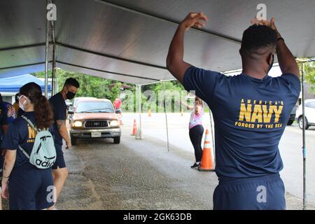 AGAT, Guam (agosto 13, 2021) - i marinai di USS Emory S. Land (AS 39) e Visiting Marines of Combat Logistics Regiment 17 (CLR-17) si sono offerti volontariamente all’Ufficio del Sindaco di Agat per distribuire 400 pacchetti di prodotti alimentari nell’ambito del programma di assistenza alimentare d’emergenza (TEFAP), agosto 12. Le materie prime sono rese possibili attraverso il Guam Department of Education attraverso il Dipartimento dell'Agricoltura degli Stati Uniti Food Nutrition Service e sono distribuite dai sindaci del villaggio a famiglie bisognose e colpite dalla pandemia COVID-19. Il 9 agosto, volontari del Land e CLR 17 hanno confezionato le 400 confezioni di cibo Foto Stock