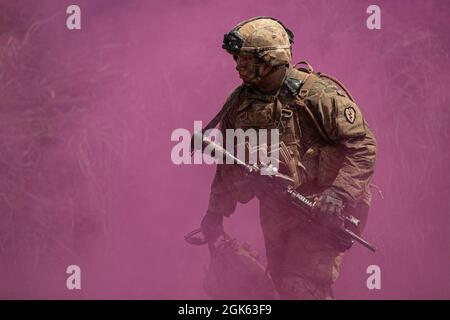 Un soldato dell'esercito degli Stati Uniti con il guerriero della Task Force cammina attraverso il fumo violetto dopo un campo di fuoco vivo all'area di addestramento di Baturaja, Indonesia, il 12 agosto 2021. Garuda Shield 21 è un'esercitazione congiunta di due settimane tra l'esercito degli Stati Uniti e l'Indonesia di Tentara Nasional (TNI-ad Indonesia Armate Forces). Lo scopo di questo esercizio congiunto è quello di migliorare e arricchire la capacità di guerra nella giungla sia dell'esercito degli Stati Uniti che dell'esercito indonesiano. Foto Stock