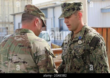 Frank Tantillo, comandante della Task Force Iron Grey, presenta medaglie di conquista dell'esercito a otto marinai della Marina degli Stati Uniti assegnati alla Maritime Expeditionary Security Force Eleven (MSRON-11) durante una cerimonia di premiazione a Camp Lemonnier, Gibuti, 12 agosto 2021. I marinai sono stati assegnati per aver contribuito alla formazione dei soldati dell'esercito degli Stati Uniti attaccati alla Dagger Company, 1-102nd reggimento di fanteria (montagna) su vari compiti come valutazioni di nuoto, tattica lotta contro le vittime e operazioni di base di piccole imbarcazioni. Foto Stock