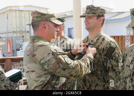 Frank Tantillo, comandante della Task Force Iron Grey, presenta medaglie di conquista dell'esercito a otto marinai della Marina degli Stati Uniti assegnati alla Maritime Expeditionary Security Force Eleven (MSRON-11) durante una cerimonia di premiazione a Camp Lemonnier, Gibuti, 12 agosto 2021. I marinai sono stati assegnati per aver contribuito alla formazione dei soldati dell'esercito degli Stati Uniti attaccati alla Dagger Company, 1-102nd reggimento di fanteria (montagna) su vari compiti come valutazioni di nuoto, tattica lotta contro le vittime e operazioni di base di piccole imbarcazioni. Foto Stock