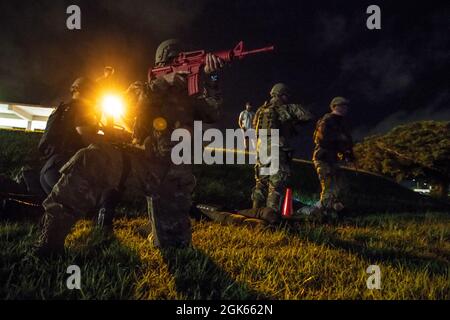 I difensori del 18 ° Squadron delle forze di sicurezza forniscono assistenza in caso di incidente durante la simulazione del fuoco durante il Defender Flight of the Quarter Challenge sulla base aerea di Kadena, Giappone, 12 agosto 2021. Ogni trimestre il 18° SFS conduce il Defender Challenge per evidenziare i migliori performer per ogni volo, le abilità hone e aumentare il morale dell'unità. Foto Stock