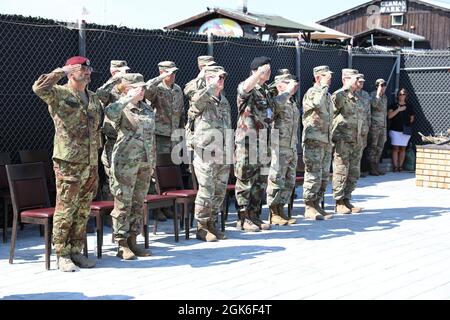 Distinti ospiti salutano mentre l'inno nazionale degli Stati Uniti suona durante una cerimonia di trasferimento di autorità a Camp Film City, Pristina, Kosovo sabato 14 agosto 2021. Il team di comando uscente dell'elemento di supporto Nazionale dei Balcani, il Lt. Col. James Grimaldi e il comando Sgt. Il Major William Adams trasferì l'autorità di comando del BNSE al comandante in arrivo il Major Jasen Boyd e il CSM Matthew Lang. Soldati, Airmen e Marines del BNSE, insieme ad una varietà di illustri ospiti, erano presenti alla cerimonia. Foto Stock