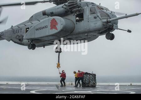 210814-N-YP246-1075 OCEANO PACIFICO (AGOSTO 14, 2021) i marinai praticano un rifornimento verticale con un MH-53E elicottero Sea Dragon della miniera di elicottero contromisure Squadron quattordici (HM) 14 a bordo della nave da trasporto anfibio USS Green Bay (LPD 20). Green Bay, parte di Amphibious Squadron 11, opera nell'area di responsabilità della settima flotta degli Stati Uniti per migliorare l'interoperabilità con alleati e partner e funge da pronta forza di risposta per difendere la pace e la stabilità nella regione Indo-Pacific. Foto Stock