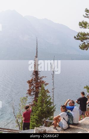 Wyoming, USA - 8 agosto 2021: Fumo nell'aria dalle vicine fiamme selvatiche estive nel Grand Teton National Park nel Wyoming, presso il lago Jenny. Turisti Foto Stock