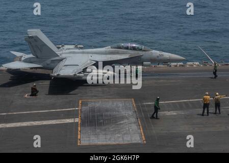 I marinai dirigono un velivolo di attacco elettronico EA-18G Growler, attaccato agli “Shadowhawks” di Electronic Attack Squadron (VAQ) 141, sul ponte di volo della portaerei USS Ronald Reagan (CVN 76) nel Mare Arabico, agosto 16. Ronald Reagan è il fiore all'occhiello del Carrier Strike Group 5 ed è dislocato nell'area della 5a flotta degli Stati Uniti di operazioni a sostegno delle operazioni navali per garantire la stabilità e la sicurezza marittima nella regione centrale, Collegare il Mediterraneo e il Pacifico attraverso l'Oceano Indiano occidentale e tre punti di arresto strategici. Foto Stock