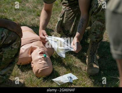 SPC. Grant Tardiff, un soldato della Guardia Nazionale dalla 147th Human Resources Company, apre un sigillo toracico per praticare il posizionamento corretto durante il corso di combattimento salvavita a Fort McCoy, Wisconsin, 17 agosto 2021. Il corso di combattimento salvavita dà ai soldati non medici la sicurezza di eseguire misure salvavita, come l'applicazione di un tourniquet o l'apertura di una via aerea, quando un medico di combattimento non è disponibile. Foto Stock