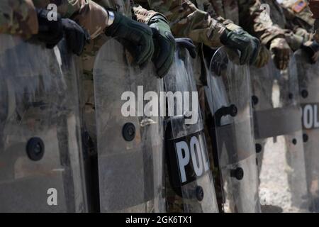 Soldati della riserva dell'esercito dalla 447a compagnia di polizia militare, con base nel Cantone del Nord, treno dell'Ohio con gli scudi della sommossa durante l'addestramento di disordini civili 18 agosto 2021 al centro di addestramento delle forze congiunte di Camp Shelby, La formazione è stata parte del processo di mobilitazione per la 447th MP Co. Che si sta dispiegando all'estero a sostegno di missioni future / in corso. Foto Stock