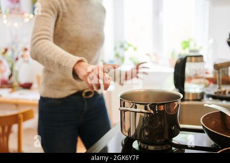 Berlino, Germania. 29 aprile 2021. Una madre salta alla pentola calda in cucina. Credit: Annette Riedl/dpa/Alamy Live News Foto Stock