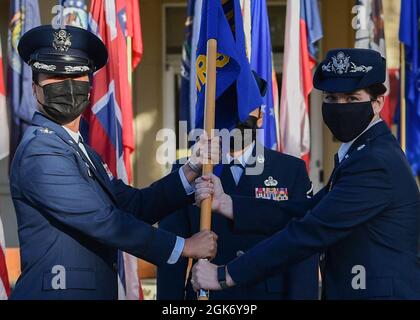 Il colmo Shawn Garcia, assume il comando del 15° Squadrone di pronto medico operativo accettando la guidon del colon Stephanie Ku, 15° comandante del gruppo medico, durante una cerimonia di comando presso la base congiunta Pearl Harbor-Hickam, Hawaii, 18 agosto 2021. Il 15° OMRS è composto da sette voli, ciascuno con una funzione specifica che fornisce assistenza medica agli Airmen in servizio attivo. Foto Stock