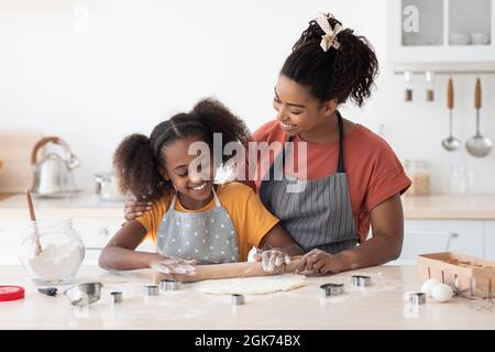 Madre amorevole che aiuta la sua figlia teen con cottura Foto Stock