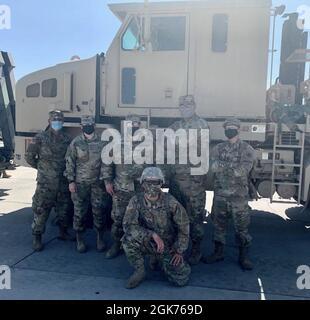 Istruttore di guida, SPC. Vasquez, e i soldati si pongono di fronte a un M1070-A1, dopo aver completato un esercizio di addestramento di Heavy Equipment Transporter (HET) presso la base dell'aeronautica di Nellis, Never. Foto Stock