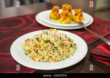 Piatto di riso con verdure assortite preparato e servito al tavolo di un ristorante cinese Foto Stock