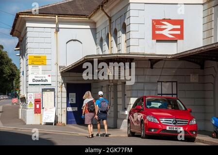 Dawlish, Devon, Inghilterra, Regno Unito. 2021. Edificio della stazione ferroviaria di Dawlish, vista esterna con auto parcheggiata e passeggeri. Foto Stock