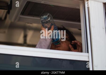 Un bambino afghano beve acqua su un autobus durante un'operazione di evacuazione non combattente alla base aerea Ali al Salem, Kuwait, 23 agosto 2021. Foto Stock