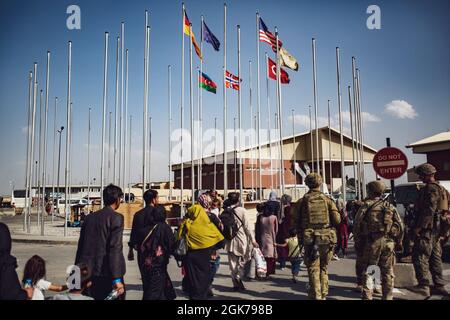 I soldati assegnati alla 82° Divisione Airborne accompagnano un gruppo di persone al terminal dell'aeroporto internazionale Hamid Karzai, 23 agosto. I membri del servizio degli Stati Uniti stanno assistendo il Dipartimento di Stato con un'operazione DI evacuazione non combatante (NEO) in Afghanistan. Foto Stock