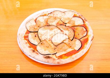 Pizza a fette di melanzana con aglio e pomodoro a base di farina di grano su tavola di legno Foto Stock