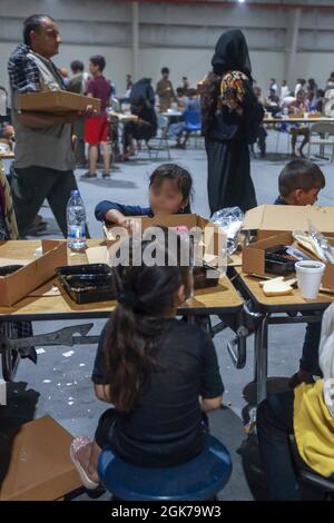 Gli evacuati afghani mangiano il pranzo a Camp come Sayliyah, Qatar, 30 agosto 2021. I soldati continuano a sostenere gli sforzi di evacuazione del Dipartimento della Difesa e del Dipartimento di Stato in Afghanistan con cura e compassione in varie sedi del comando Centrale degli Stati Uniti. (STATI UNITI Army Foto di SPC. Aaliyah Craven) Foto Stock