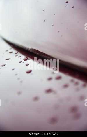 Astratto arte texture sfondo di gocce di pioggia su marrone rosso lucido acciaio inossidabile spazzolato superficie in metallo su vecchio retro auto d'epoca tetto e paraurti Foto Stock