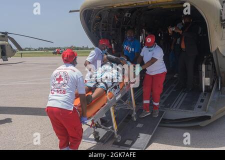 Croix-Rouge haiienne evacuare una vittima a Port-au-Prince, Haiti, 23 agosto 2021. Joint Task Force-Bravo, Soto Cano Air base, Honduras, su richiesta della United Southern Command Task Force-Haiti, i membri del servizio si sono schierati per sostenere gli sforzi di soccorso per la popolazione di Haiti dopo che la nazione è stata colpita dal terremoto del 14 agosto. Foto Stock