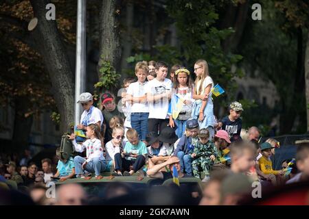 I bambini ucraini guardano la sfilata del giorno dell'Indipendenza dalla cima di un veicolo a Kiev, Ucraina, 24 agosto 2021. Durante la celebrazione c'era un volo aereo e una sfilata di unità militari, veicoli e bande che si spostavano oltre il Maidan, per celebrare i 30 anni di indipendenza. Foto Stock