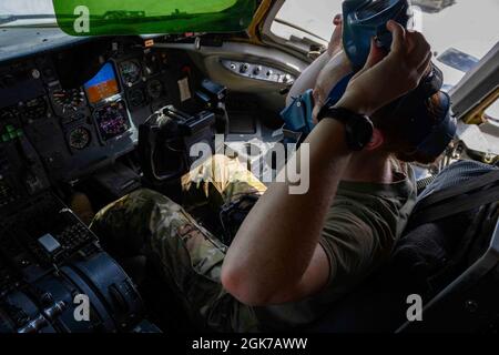 Il 1° Lt. Liza Matson, co-pilota dell'Extender KC-10 assegnato al 908o Squadrone Expeditionary Air Refeeling, testa la sua maschera di ossigeno prima del decollo di un volo "senza equipaggio" alla base aerea di al Dhafra, Emirati Arabi Uniti il 13 agosto 2021. In onore della Giornata dell’uguaglianza delle donne, riconosciuta ogni anno il 26 agosto per celebrare l’importanza del movimento per il suffragio delle donne e il lavoro svolto per garantire ed espandere gli stessi diritti oggi, la 380a AEW ha condotto una missione aerea di rifornimento supportata da membri esclusivamente femminili dell’equipaggio, da squadre di manutenzione e di supporto al volo. Foto Stock