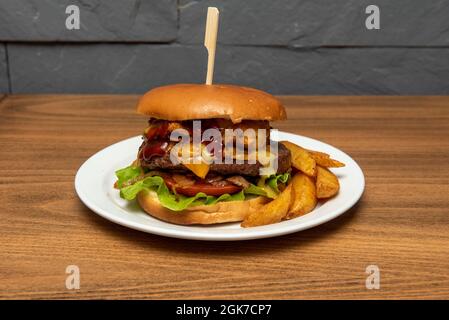 Hamburger misto con filetto di manzo con pomodoro, cipolla stufata, formaggio cheddar fuso, filetto di pollo in pastella e salsa di ketchup e senape Foto Stock